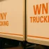 Enhanced brand consistency with two identical WNY TRUCKING trailers showing matching orange logos.