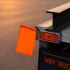 Corner of a flatbed trailer with orange safety flag and reflector highlighting safe flatbed trucking for extended loads